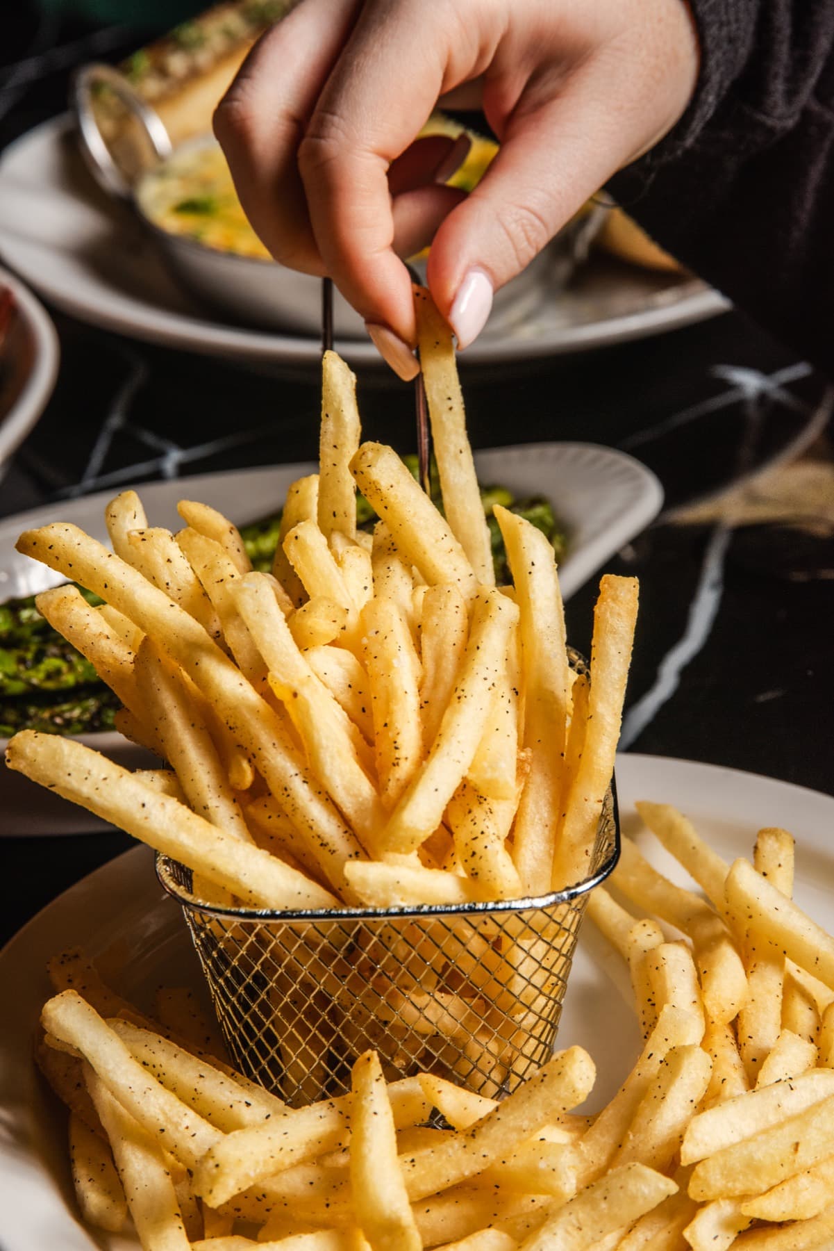 A guest reaching for seasoned fries
